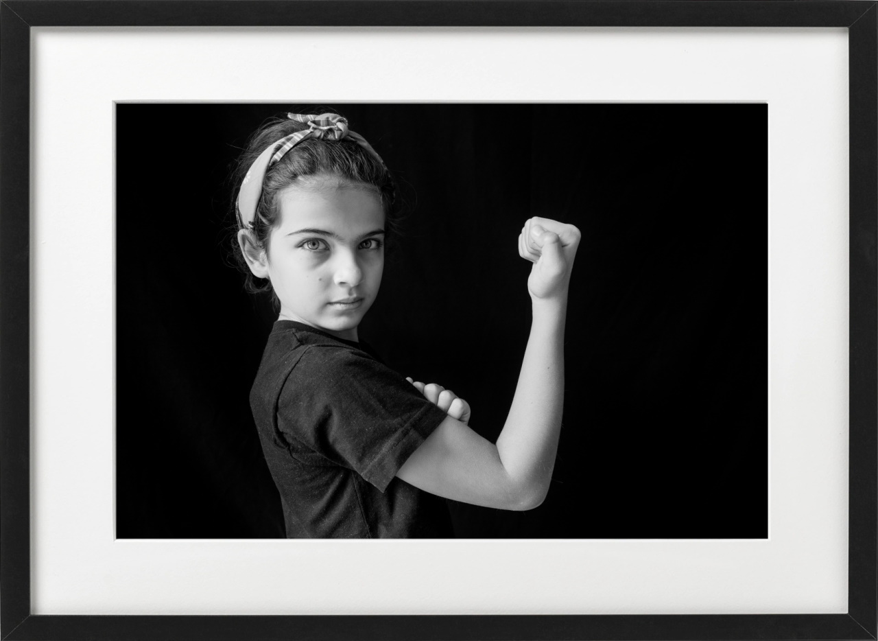 Black and white portrait of a girl showing her muscle